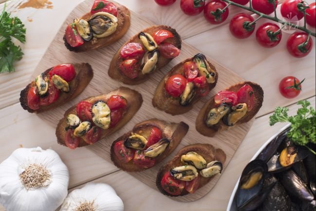 Crostini with mussels and cherry tomatoes - Italian recipes by GialloZafferano