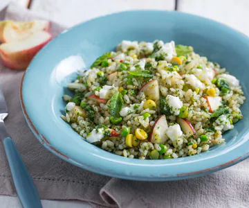 Rice salad with peaches, peas and stracchino cheese