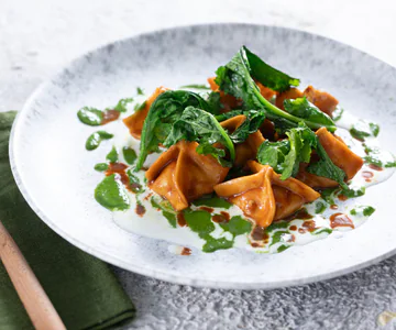 Shrimp ravioli with stracciatella and turnip greens