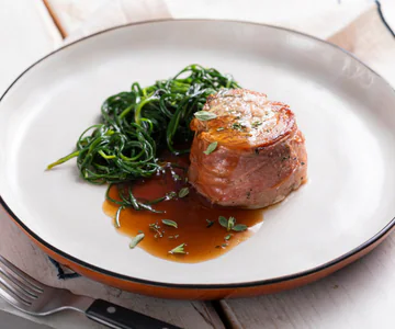 Pork tenderloin wrapped in speck with agretti