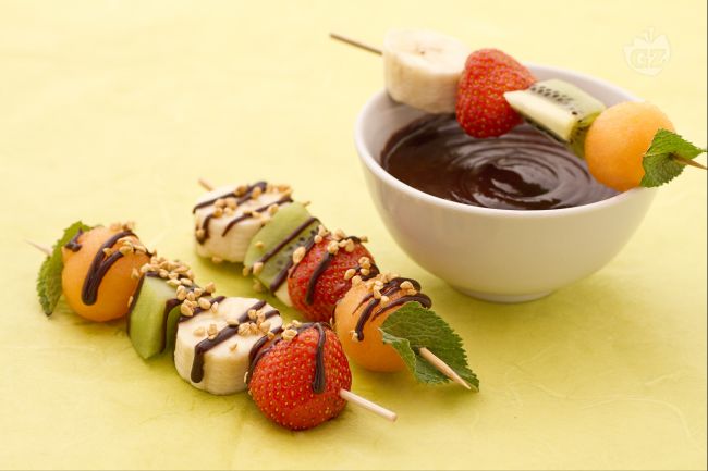 Fruit skewers with chocolate sauce and hazelnut crumble - Italian recipes by GialloZafferano