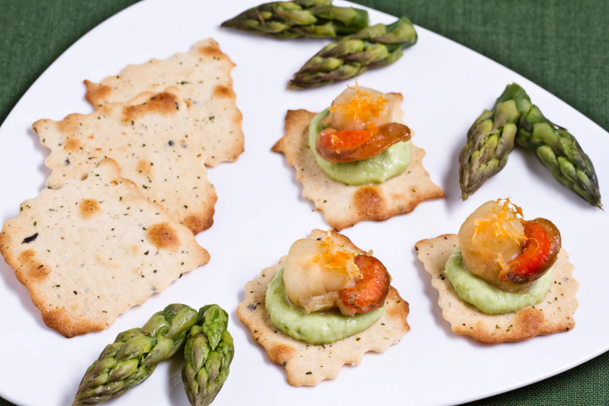 Puff pastries with olives, scallops, and asparagus cream