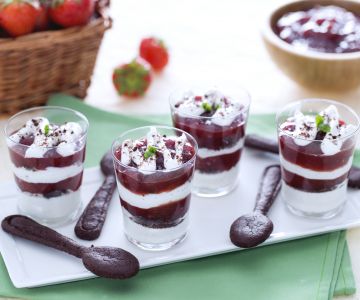 Glasses with yogurt cream, strawberry jam and cocoa sable cookies