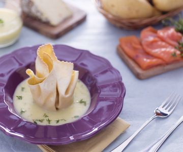 Fresh pasta bundle with salmon, toma cheese and radicchio on potato cream