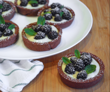 Cocoa tartlets with cream and blackberries