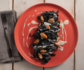 Tagliatelle with squid ink with pecorino, mussels, and lard