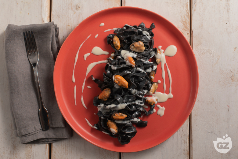 Tagliatelle with squid ink with pecorino, mussels, and lard