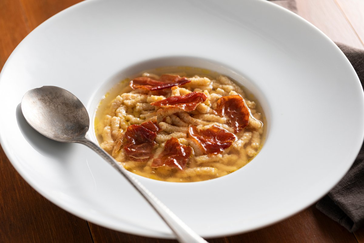 Passatelli with ham in meat broth