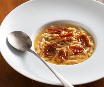 Passatelli with ham in meat broth