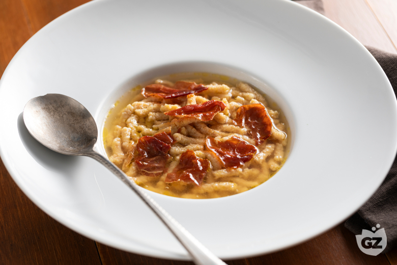 Passatelli with ham in meat broth