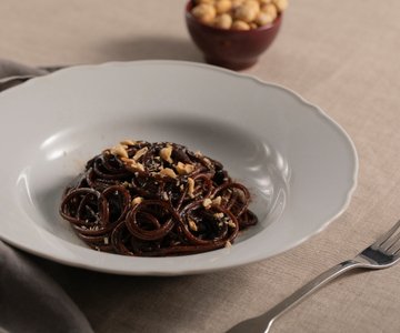 Spaghetti with black garlic cream, licorice, and hazelnuts