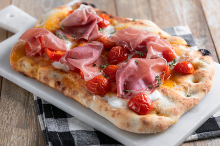 Pinsa with cured ham, cherry tomatoes and mozzarella