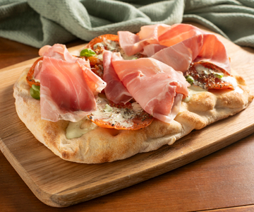 Pinsa with roasted tomatoes, burrata and cooked ham