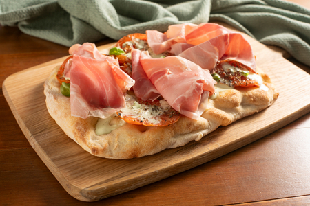 Pinsa with roasted tomatoes, burrata and cooked ham