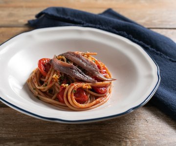 Whole-wheat pasta with anchovies, cherry tomatoes and lemon zest