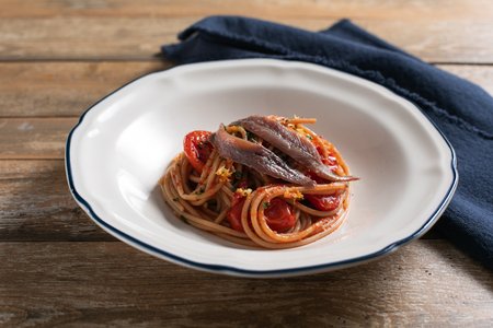 Whole-wheat pasta with anchovies, cherry tomatoes and lemon zest