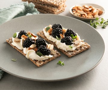 Crunchy toasts with honey cream cheese, blackberries and toasted almonds
